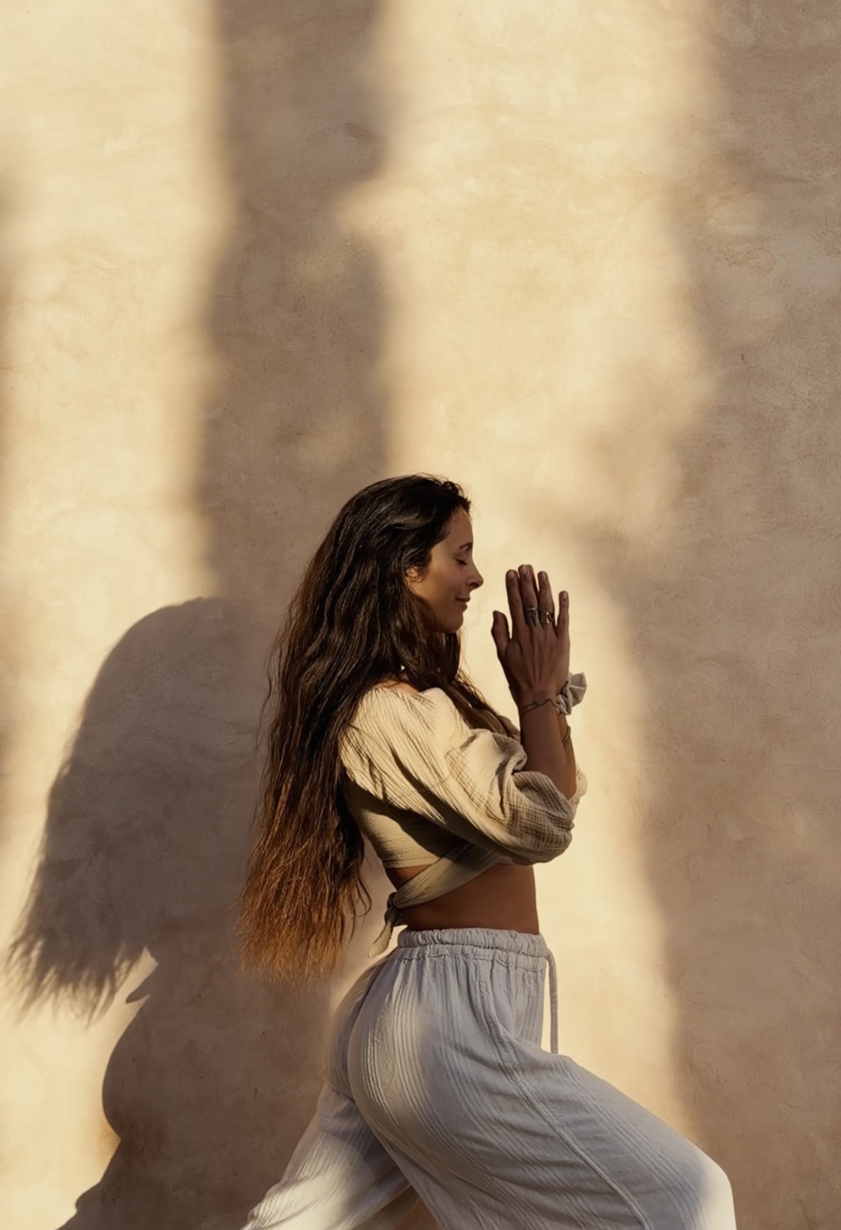 Jessica Noifeld in profile, hands together in a gesture of greeting
